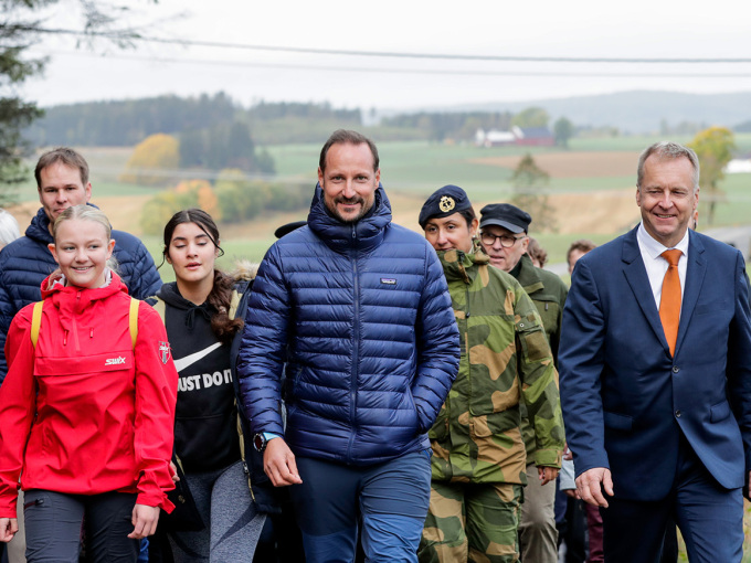 Kronprins Haakon går en del av flyktningruta sammen med Alvilde Balto Myhrvold og ordfører Saxe Frøshaug under besøket i Trøgstad. Foto: Berit Roald / NTB